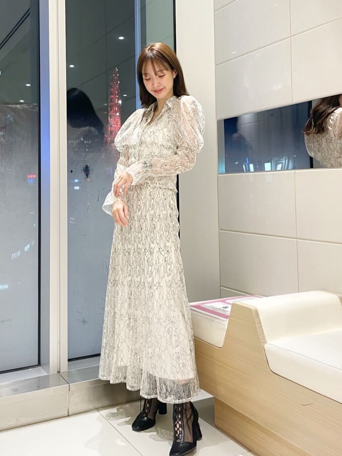 イエロー系のニット/セーター、ホワイト系のシャツ/ブラウス、ホワイト系のスカートを着用したレディースの冬コーディネートの2枚目の写真