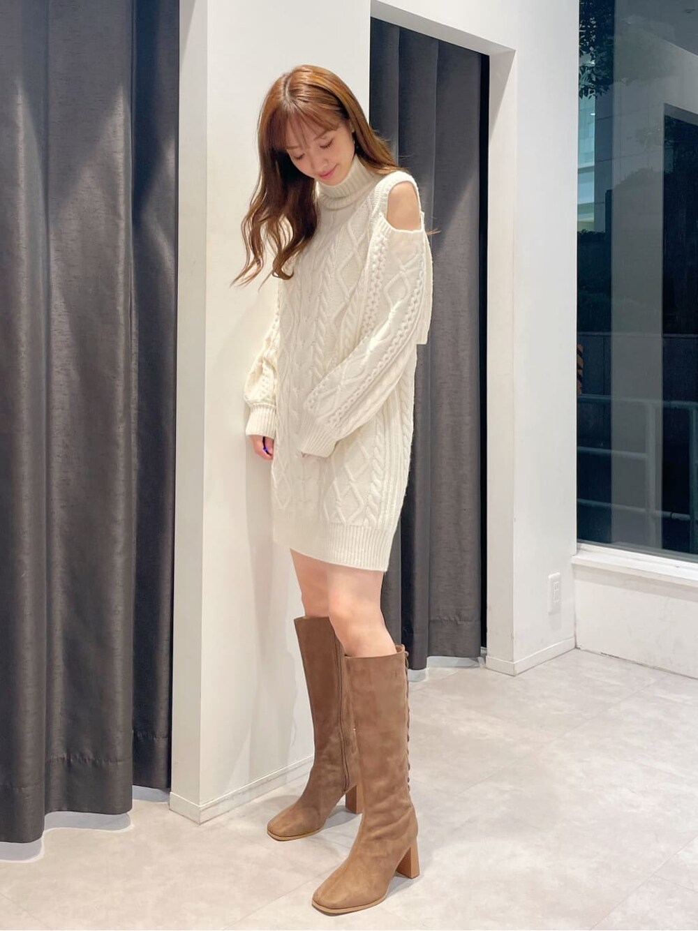 ブラウン系のブーツ、ホワイト系のワンピースを着用したレディースの秋コーディネートの3枚目の写真