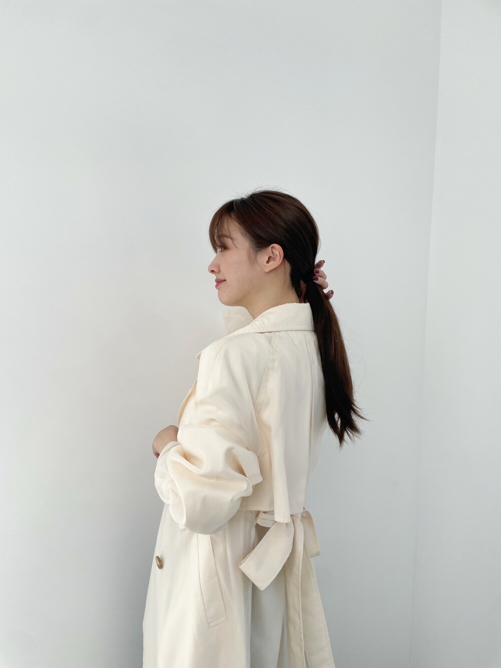 ホワイト系のトレンチコート、ブルー系のデニムスカート、ホワイト系のニット/セーターを着用したレディースの冬コーディネートの4枚目の写真