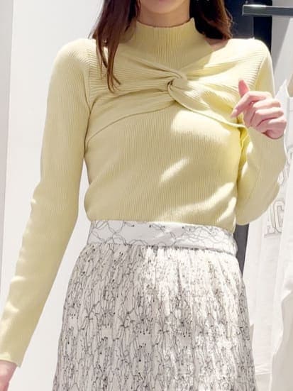 イエロー系のニット/セーター、ホワイト系のシャツ/ブラウス、ホワイト系のスカートを着用したレディースの冬コーディネートの4枚目の写真