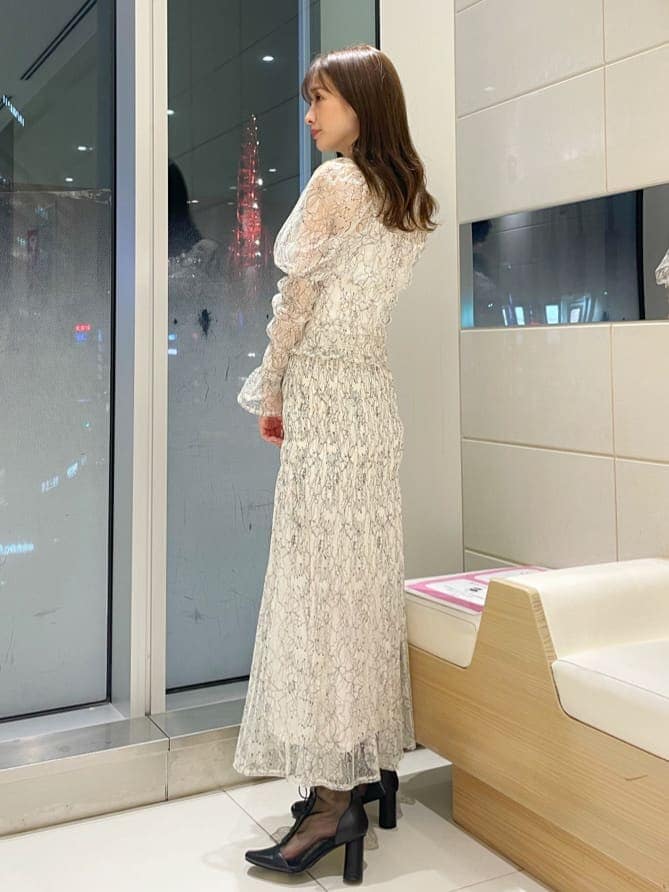 イエロー系のニット/セーター、ホワイト系のシャツ/ブラウス、ホワイト系のスカートを着用したレディースの冬コーディネートの3枚目の写真