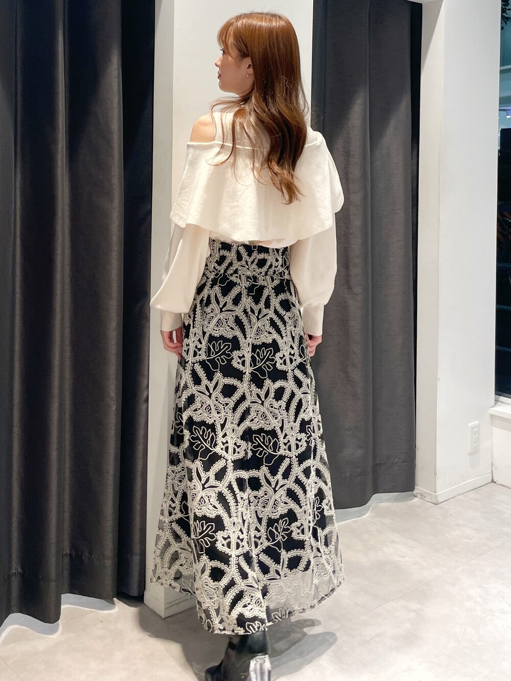 ブラウン系のダウンジャケット/コート、ホワイト系のニット/セーター、ブラック系のスカートを着用したレディースの冬コーディネートの3枚目の写真