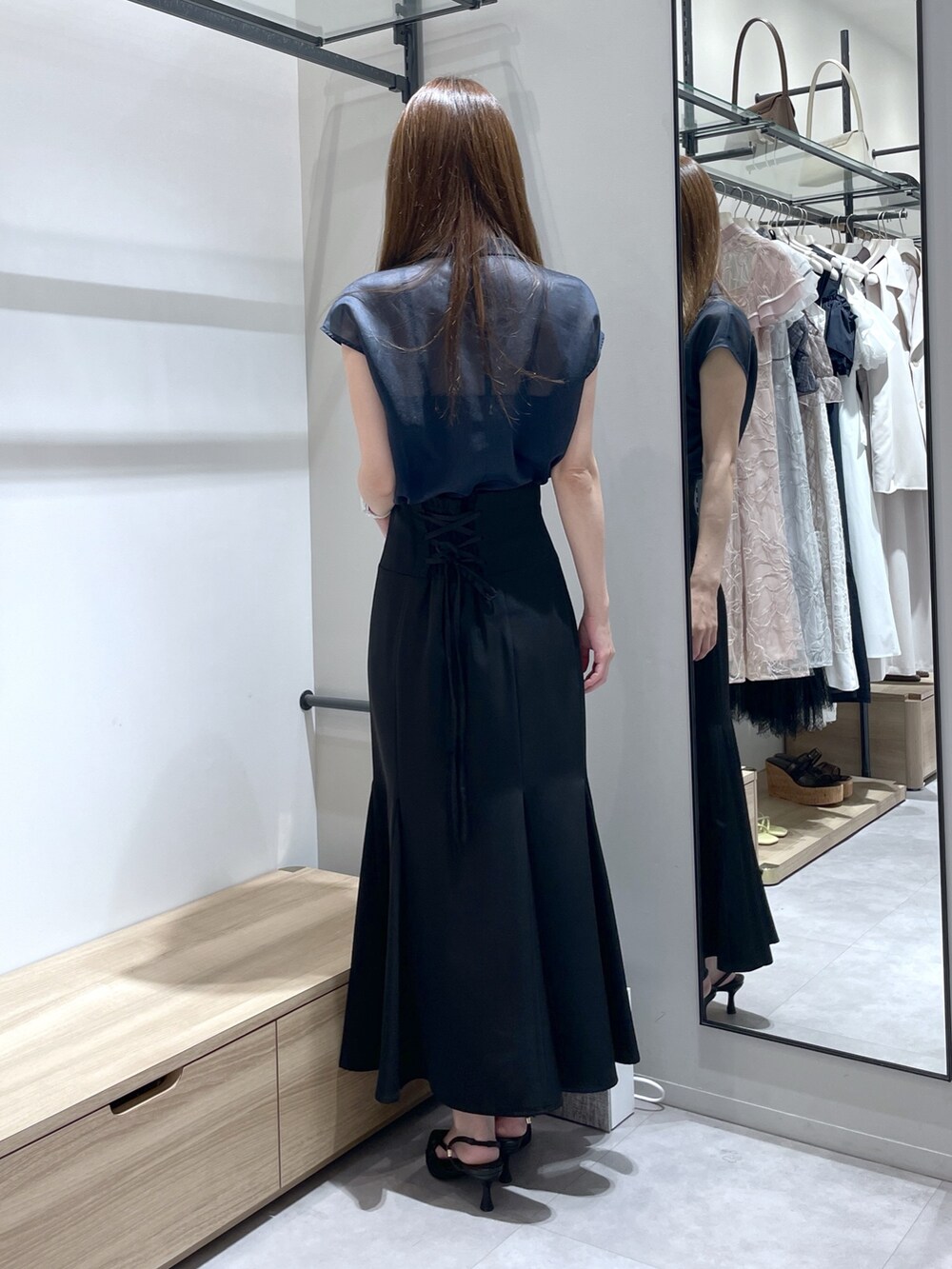 ブラック系のスカート、ブラック系のサンダル、ブルー系のシャツ/ブラウスを着用したレディースの夏コーディネートの5枚目の写真