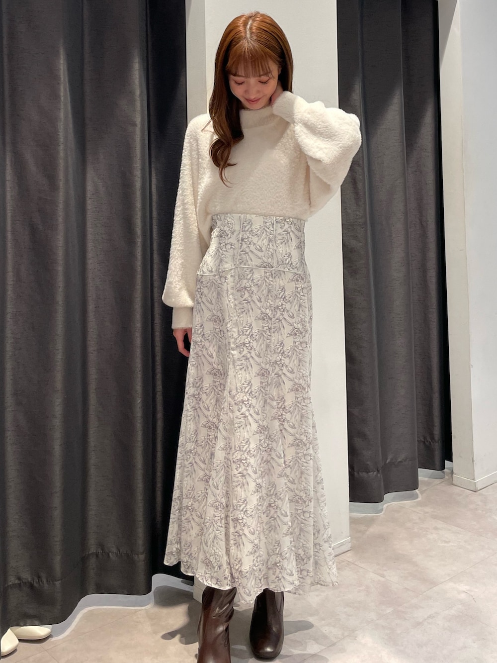 ベージュ系のダウンジャケット/コート、ホワイト系のニット/セーター、ホワイト系のスカートを着用したレディースの秋コーディネートの5枚目の写真