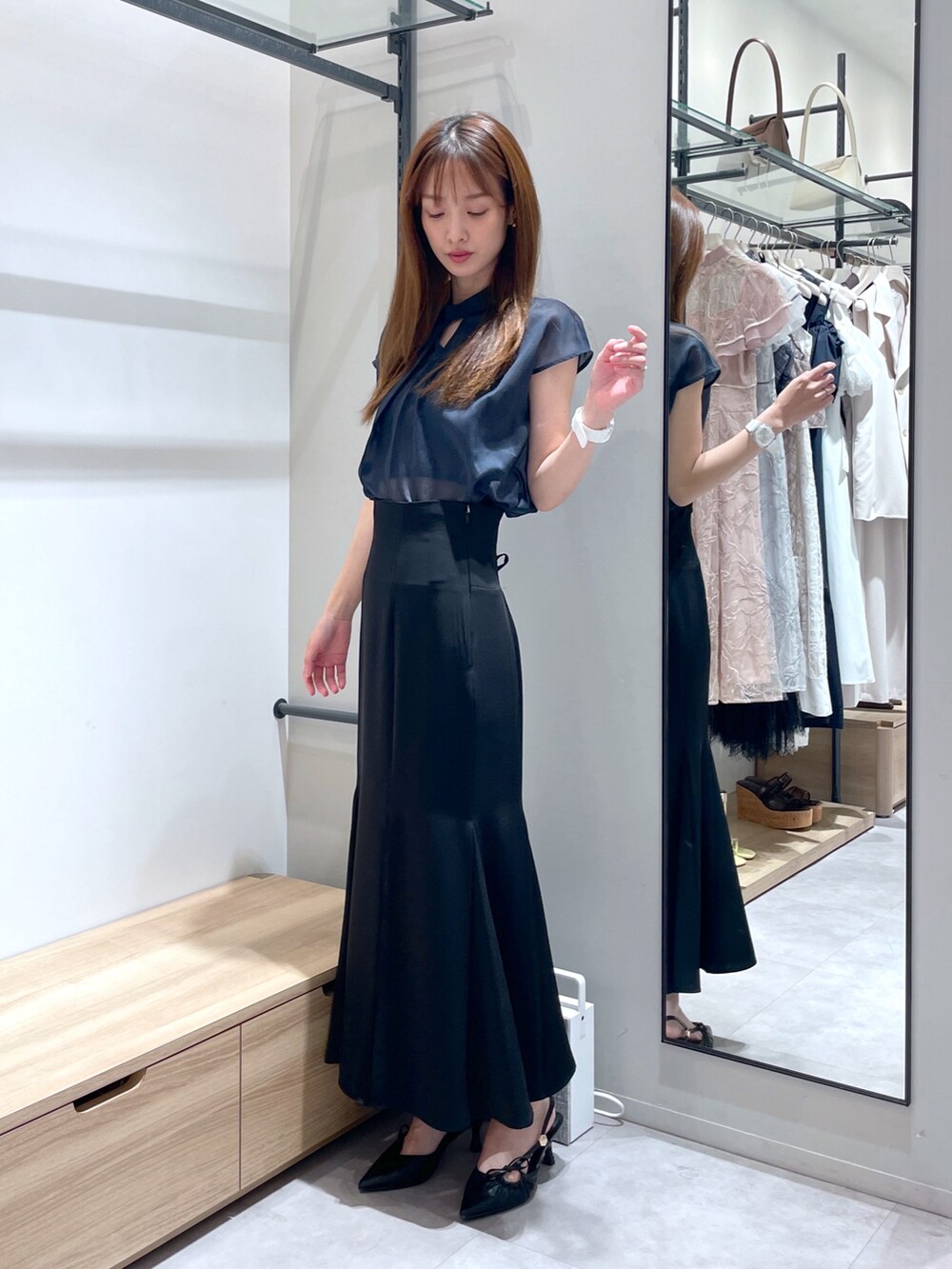 ブラック系のスカート、ブラック系のサンダル、ブルー系のシャツ/ブラウスを着用したレディースの夏コーディネートの3枚目の写真