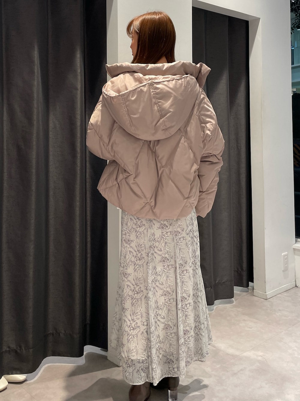 ベージュ系のダウンジャケット/コート、ホワイト系のニット/セーター、ホワイト系のスカートを着用したレディースの秋コーディネートの3枚目の写真