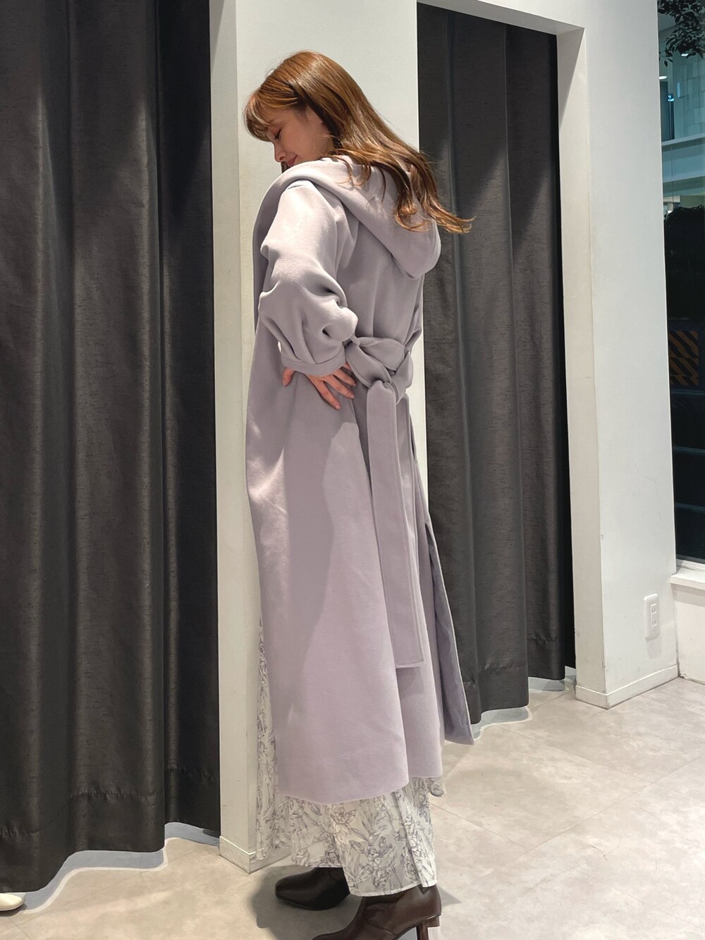 ホワイト系のニット/セーター、ホワイト系のスカート、パープル系のチェスターコートを着用したレディースの秋コーディネートの2枚目の写真