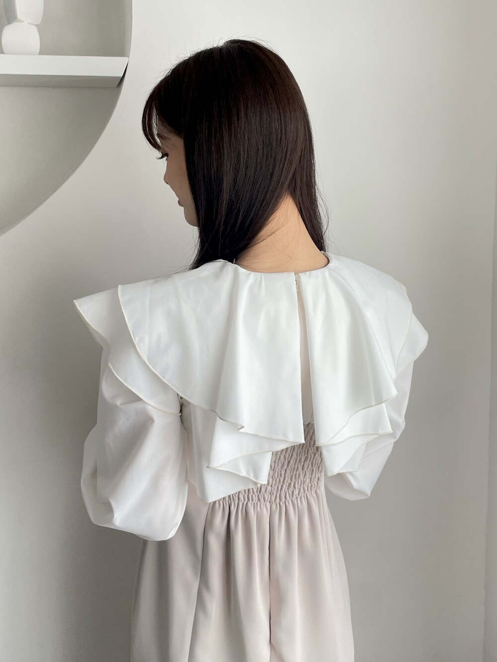 ベージュ系のワンピースを着用したレディースの冬コーディネートの4枚目の写真