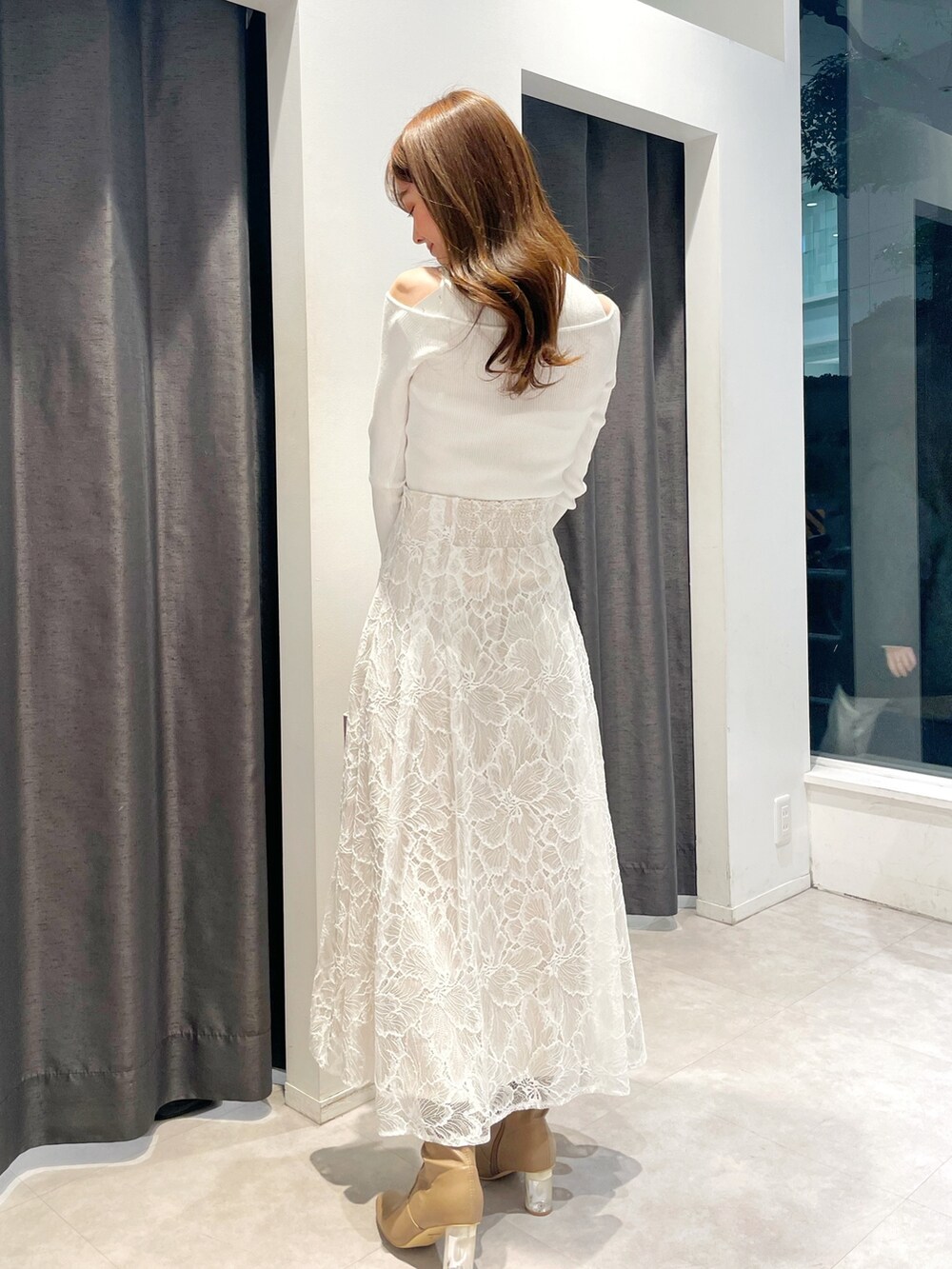 ホワイト系のスカート、ホワイト系のニット/セーター、ピンク系のトレンチコートを着用したレディースの冬コーディネートの4枚目の写真