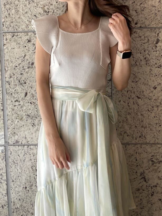 グリーン系のスカート、グリーン系のサンダル、ホワイト系のニット/セーターを着用したレディースの春コーディネートの4枚目の写真