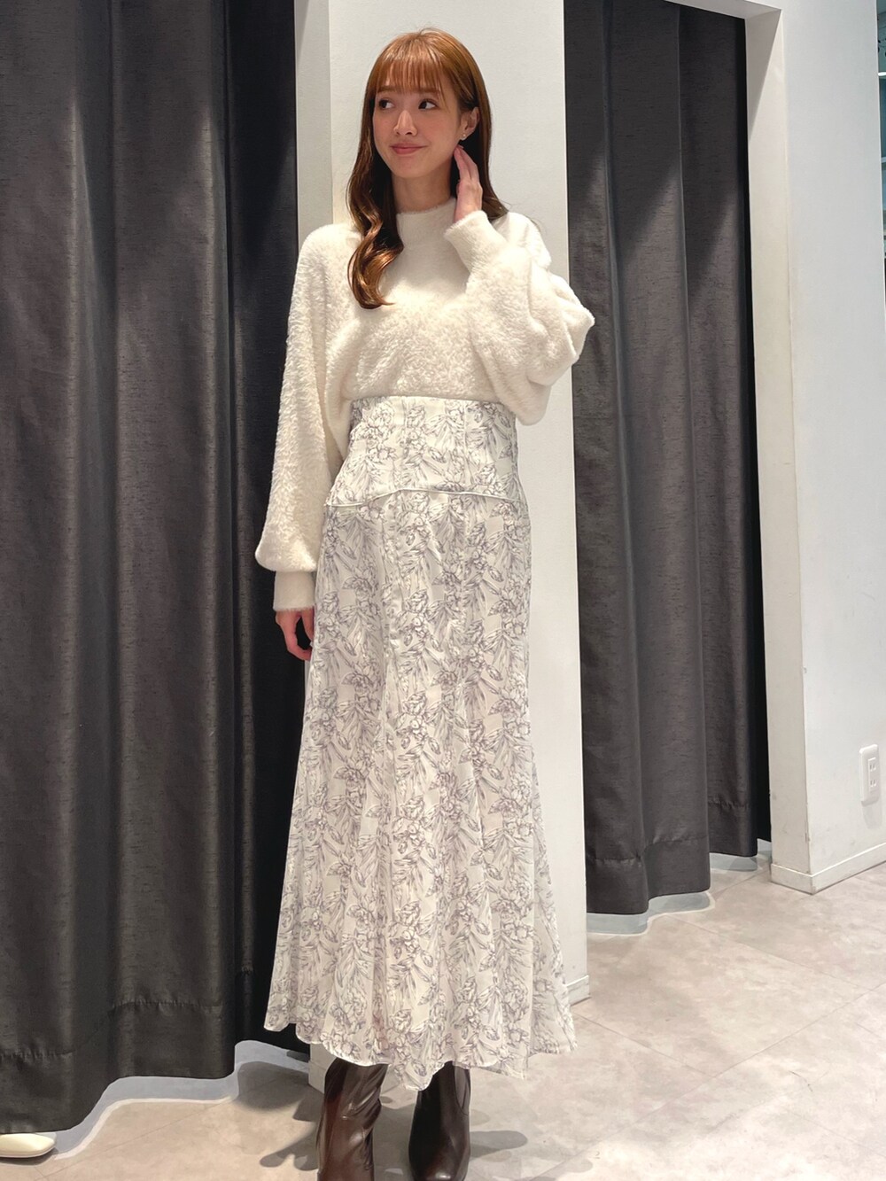 ホワイト系のニット/セーター、ホワイト系のスカート、パープル系のチェスターコートを着用したレディースの秋コーディネートの4枚目の写真