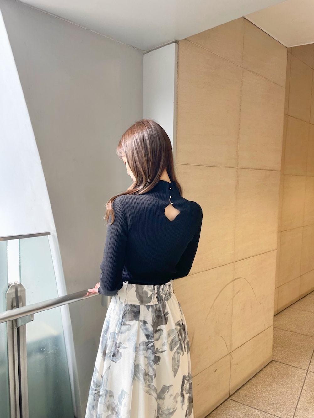 ブラック系のライダースジャケット、ブラック系のニット/セーター、ホワイト系のスカートを着用したレディースの冬コーディネートの5枚目の写真