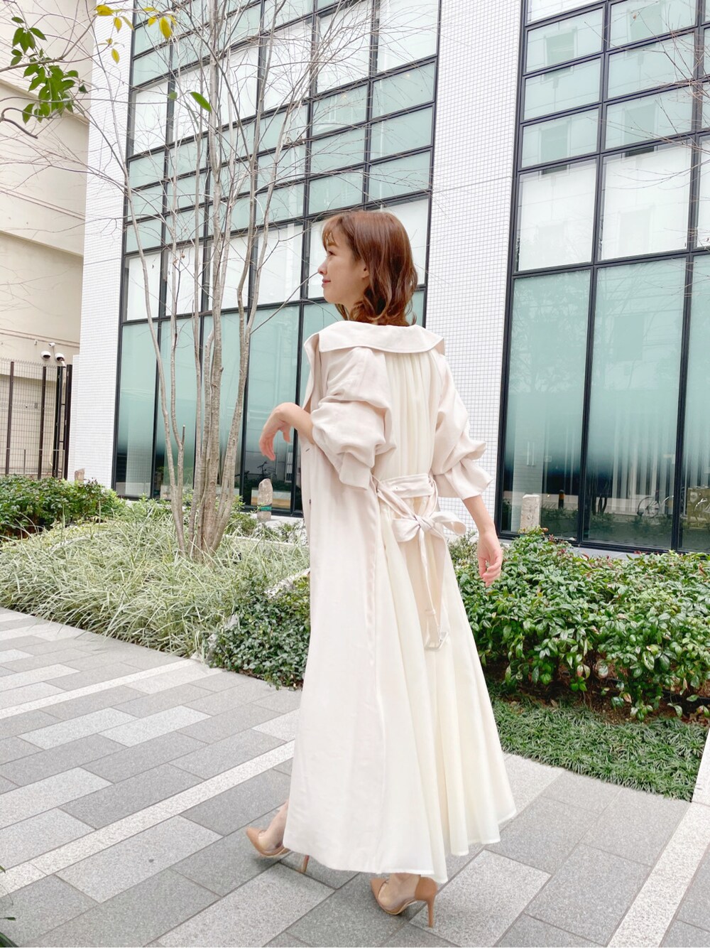 ホワイト系のトレンチコートを着用したレディースの春コーディネートの2枚目の写真