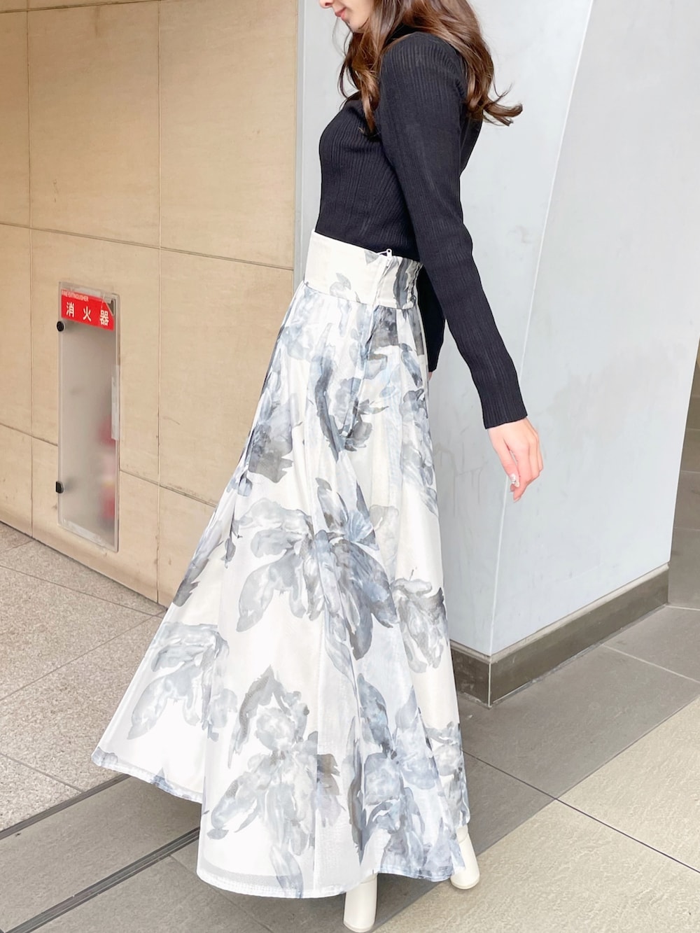 ブラック系のライダースジャケット、ブラック系のニット/セーター、ホワイト系のスカートを着用したレディースの冬コーディネートの4枚目の写真