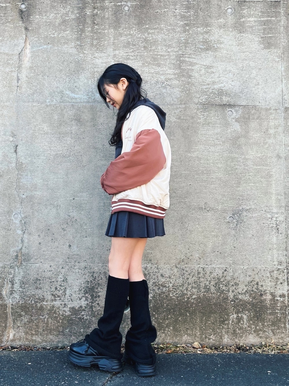 グレー系のパーカー、グレー系のスカート、ホワイト系のスタジャンを着用したレディースの冬コーディネートの3枚目の写真