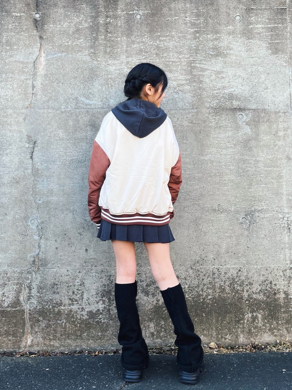 グレー系のパーカー、グレー系のスカート、ホワイト系のスタジャンを着用したレディースの冬コーディネートの4枚目の写真