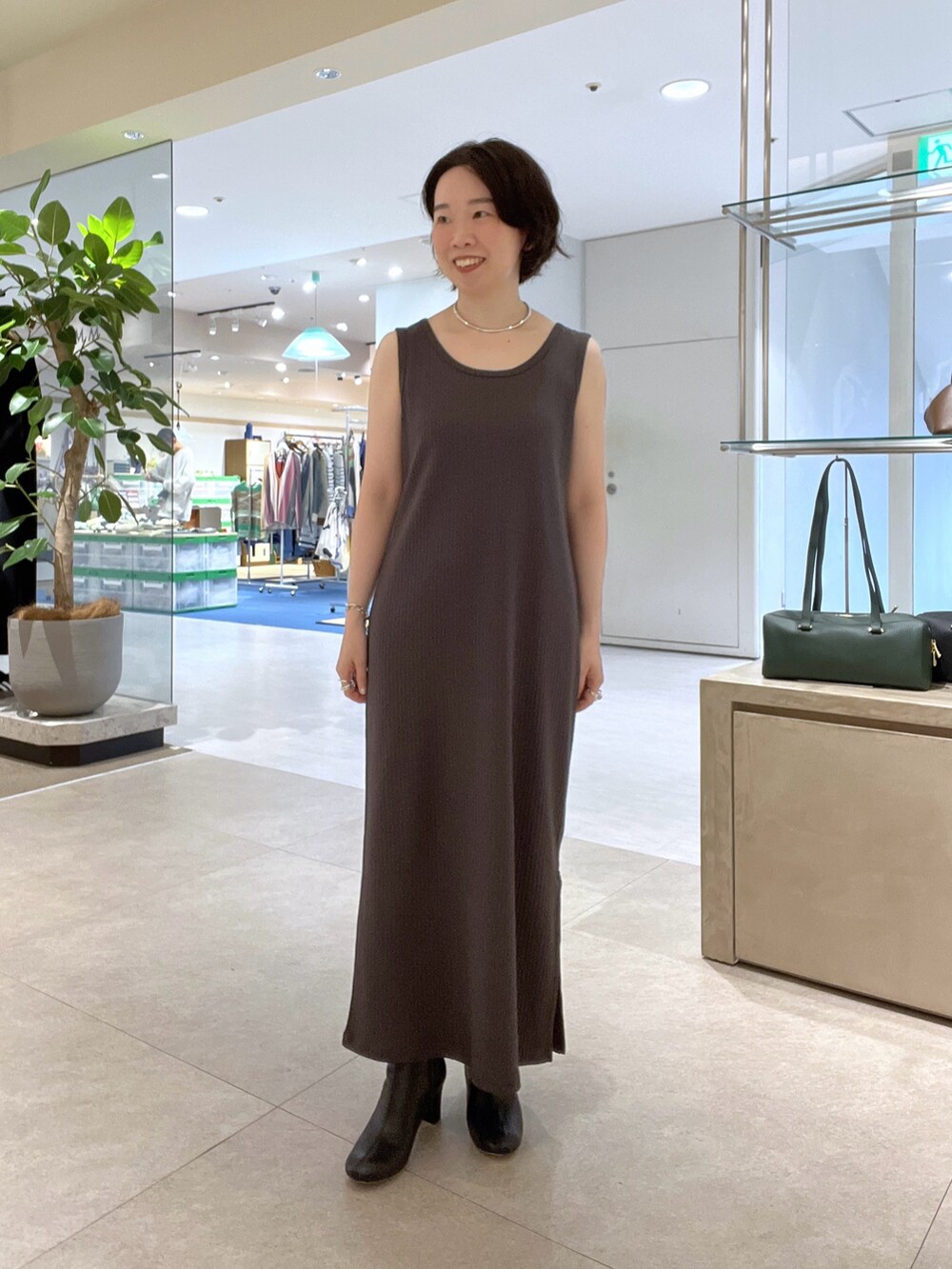 ブラウン系のワンピース、ブラック系のショルダーバッグ、ブラック系のブーツを着用したレディースの秋コーディネートの6枚目の写真