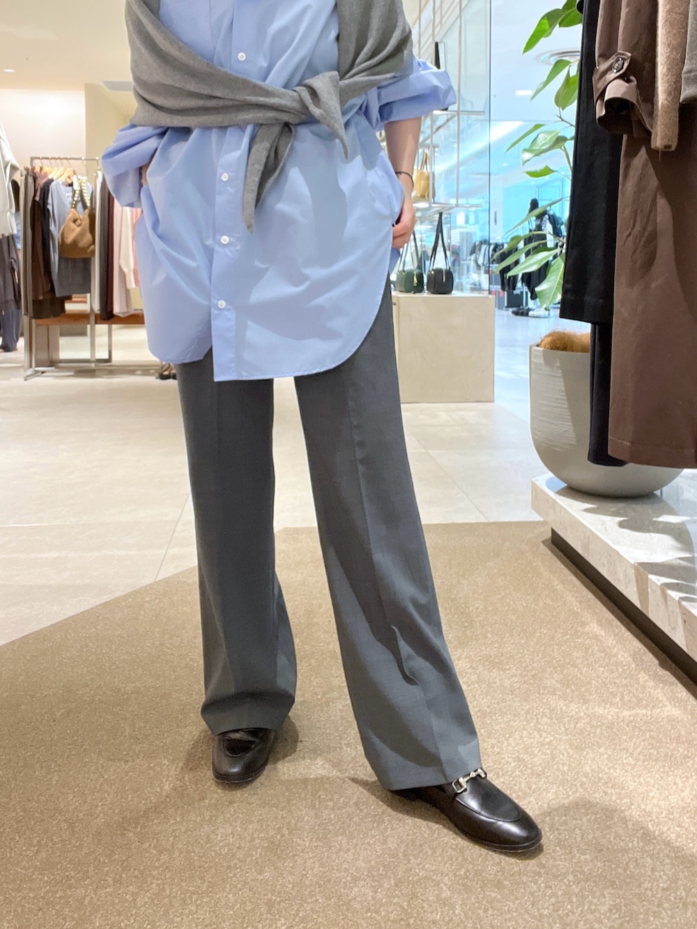 ブルー系のシャツ/ブラウス、グレー系のその他パンツ、ブラウン系のハンドバッグを着用したレディースの秋コーディネートの6枚目の写真