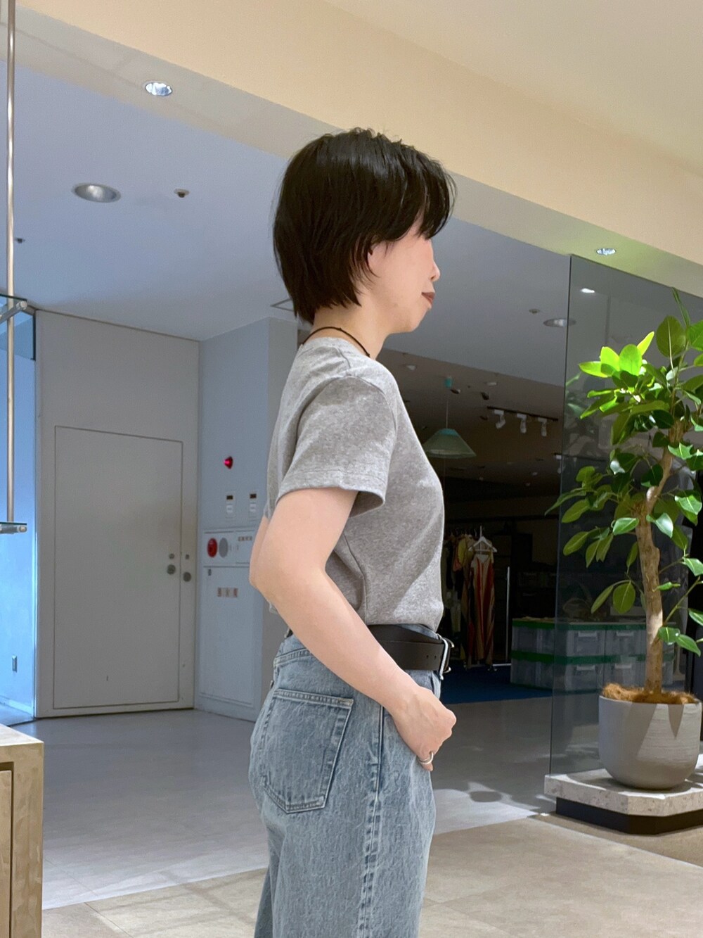 グレー系のTシャツ/カットソー、ブルー系のデニムパンツ、ブラック系のパンプスを着用したレディースの夏コーディネートの6枚目の写真