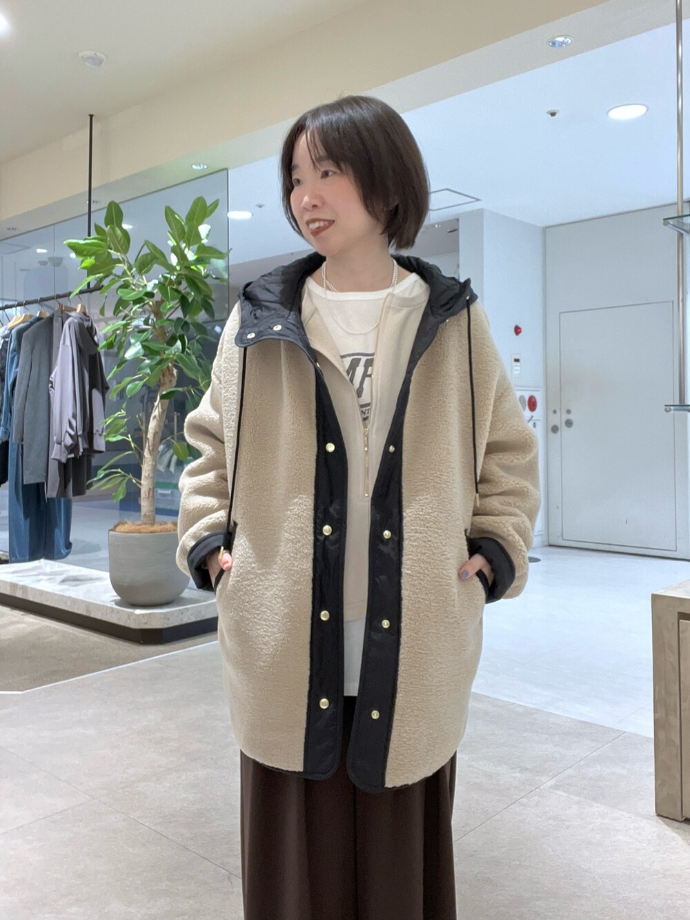 ベージュ系のその他アウター、ベージュ系のスウェット、ホワイト系のTシャツ/カットソーを着用したレディースの秋コーディネートの4枚目の写真