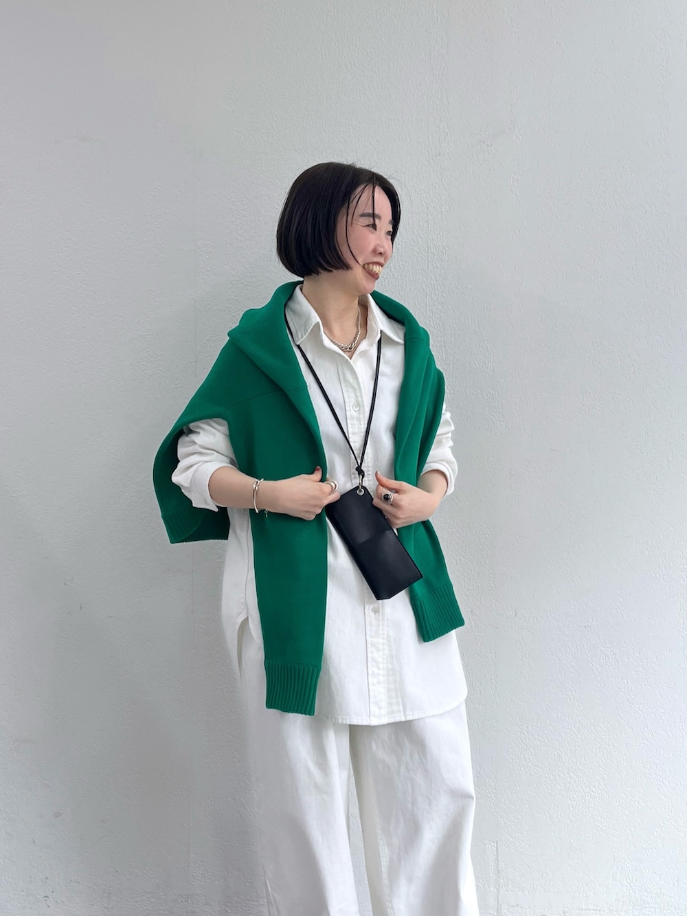ホワイト系のシャツ/ブラウス、グリーン系のニット/セーター、ホワイト系のデニムパンツを着用したレディースの冬コーディネートの5枚目の写真