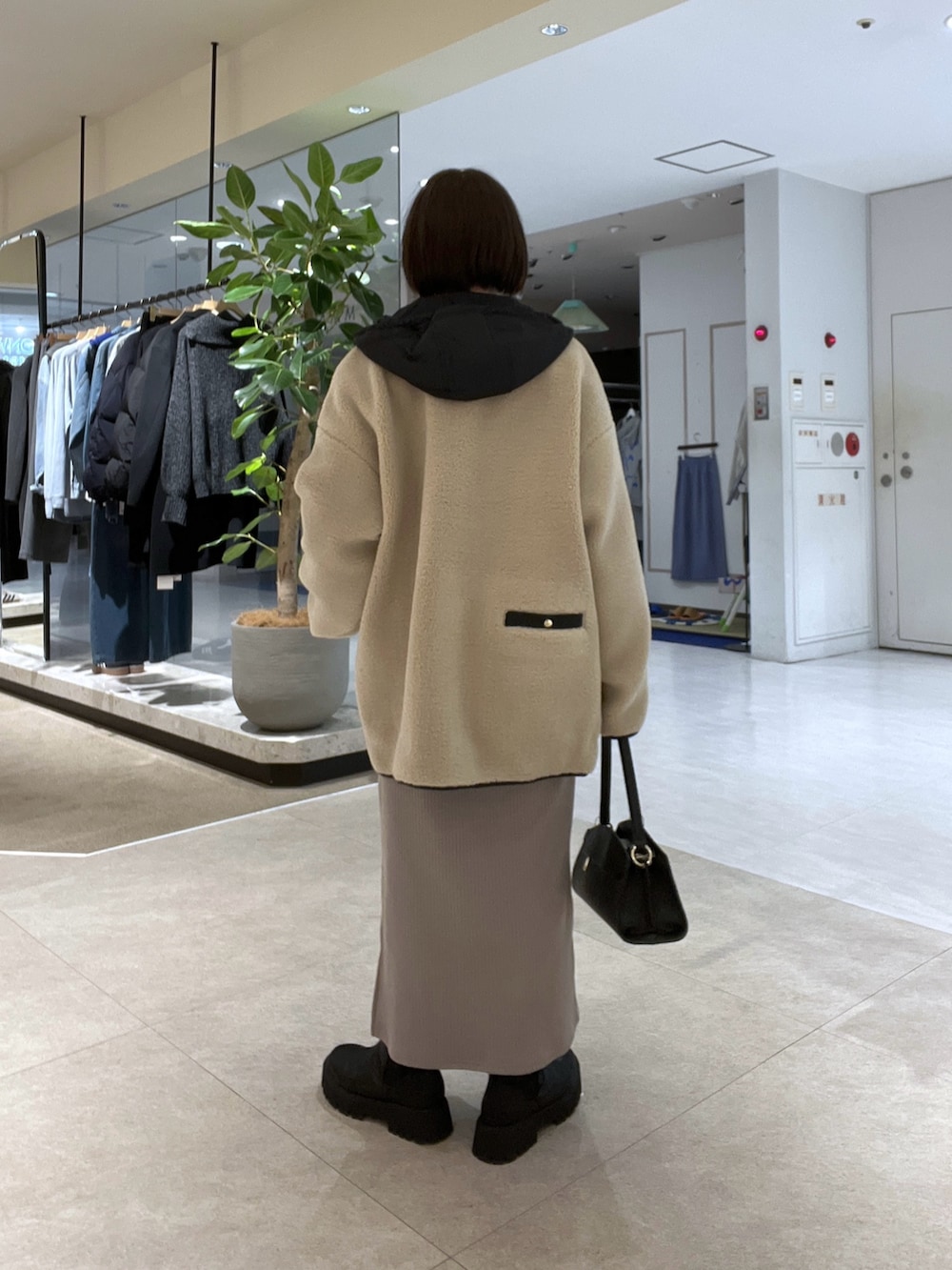 ベージュ系のその他アウター、ホワイト系のニット/セーター、ベージュ系のワンピースを着用したレディースの冬コーディネートの3枚目の写真