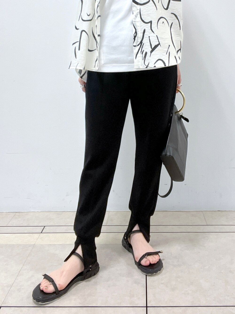 ブラック系のショルダーバッグ、ホワイト系のシャツ/ブラウス、ホワイト系のタンクトップを着用したレディースの春コーディネートの4枚目の写真