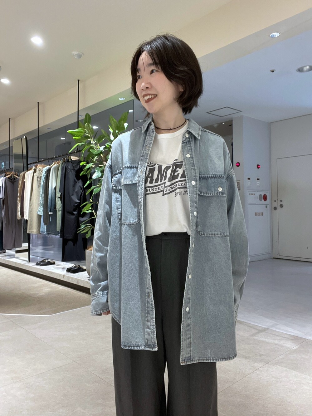 グレー系のスラックス、ホワイト系のTシャツ/カットソー、ベージュ系のその他アウターを着用したレディースの秋コーディネートの5枚目の写真