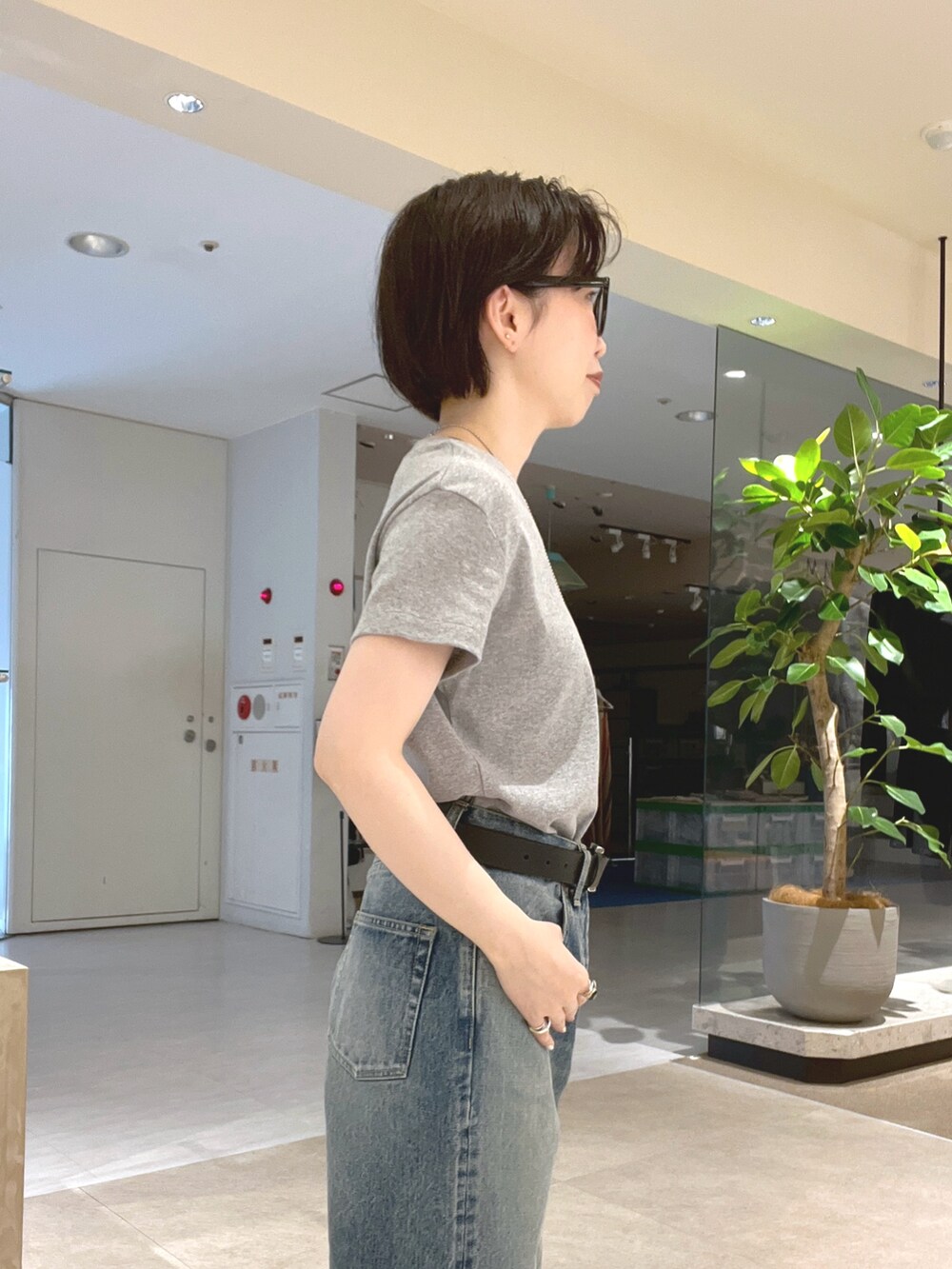 ブルー系のデニムパンツ、ブラック系のサンダル、グレー系のTシャツ/カットソーを着用したレディースの夏コーディネートの5枚目の写真