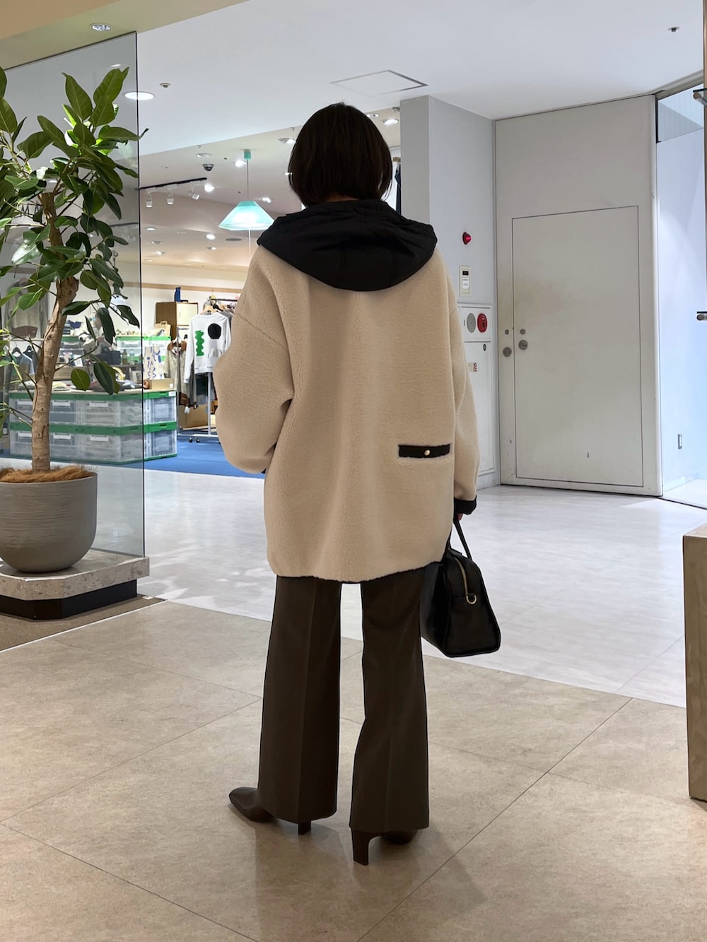 ブラック系のスウェット、ブラウン系のその他パンツ、ブラック系のボストンバッグを着用したレディースの秋コーディネートの3枚目の写真