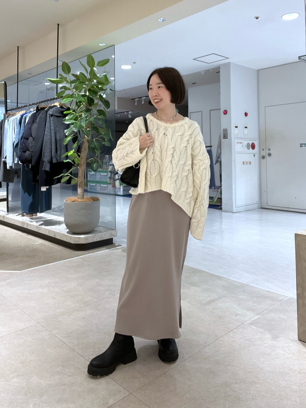 ベージュ系のその他アウター、ホワイト系のニット/セーター、ベージュ系のワンピースを着用したレディースの冬コーディネートの4枚目の写真