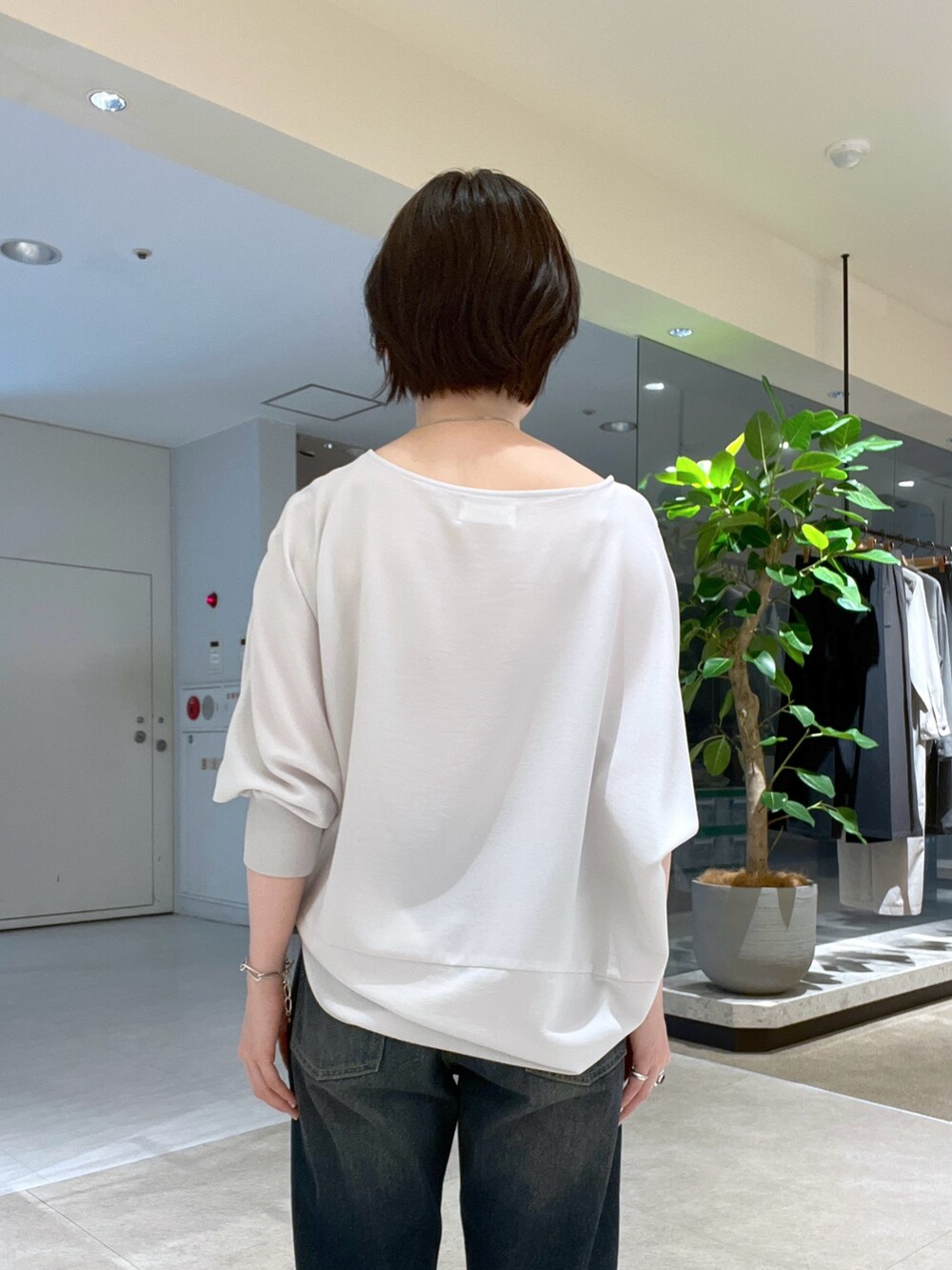 ブルー系のデニムパンツ、ブラック系のハンドバッグ、ブラック系のサンダルを着用したレディースの夏コーディネートの6枚目の写真