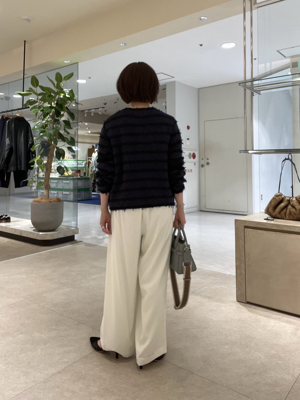 ブルー系のカーディガン/ボレロ、ホワイト系のスラックス、ブルー系のシャツ/ブラウスを着用したレディースの冬コーディネートの3枚目の写真