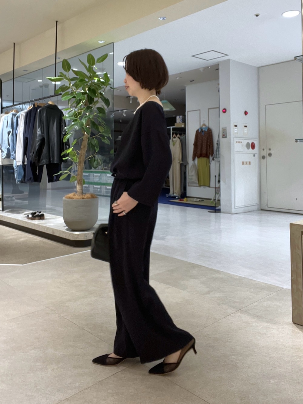 グレー系のテーラードジャケット、ブルー系のスラックス、ブラック系のボストンバッグを着用したレディースの冬コーディネートの8枚目の写真