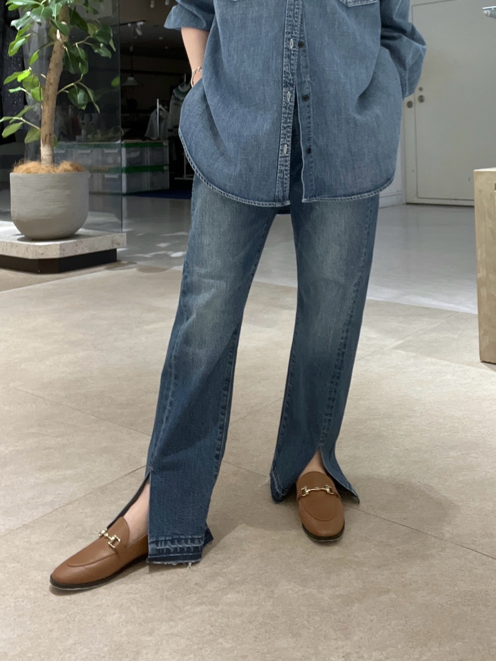 ブルー系のシャツ/ブラウス、ブルー系のデニムパンツ、イエロー系のボストンバッグを着用したレディースの冬コーディネートの7枚目の写真