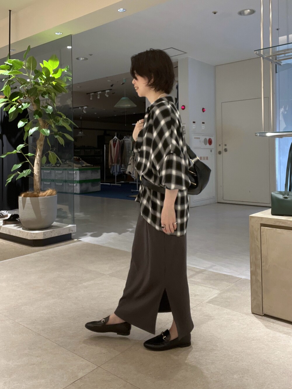 ブラック系のシャツ/ブラウス、グレー系のワンピース、ブラック系のローファーを着用したレディースの秋コーディネートの2枚目の写真