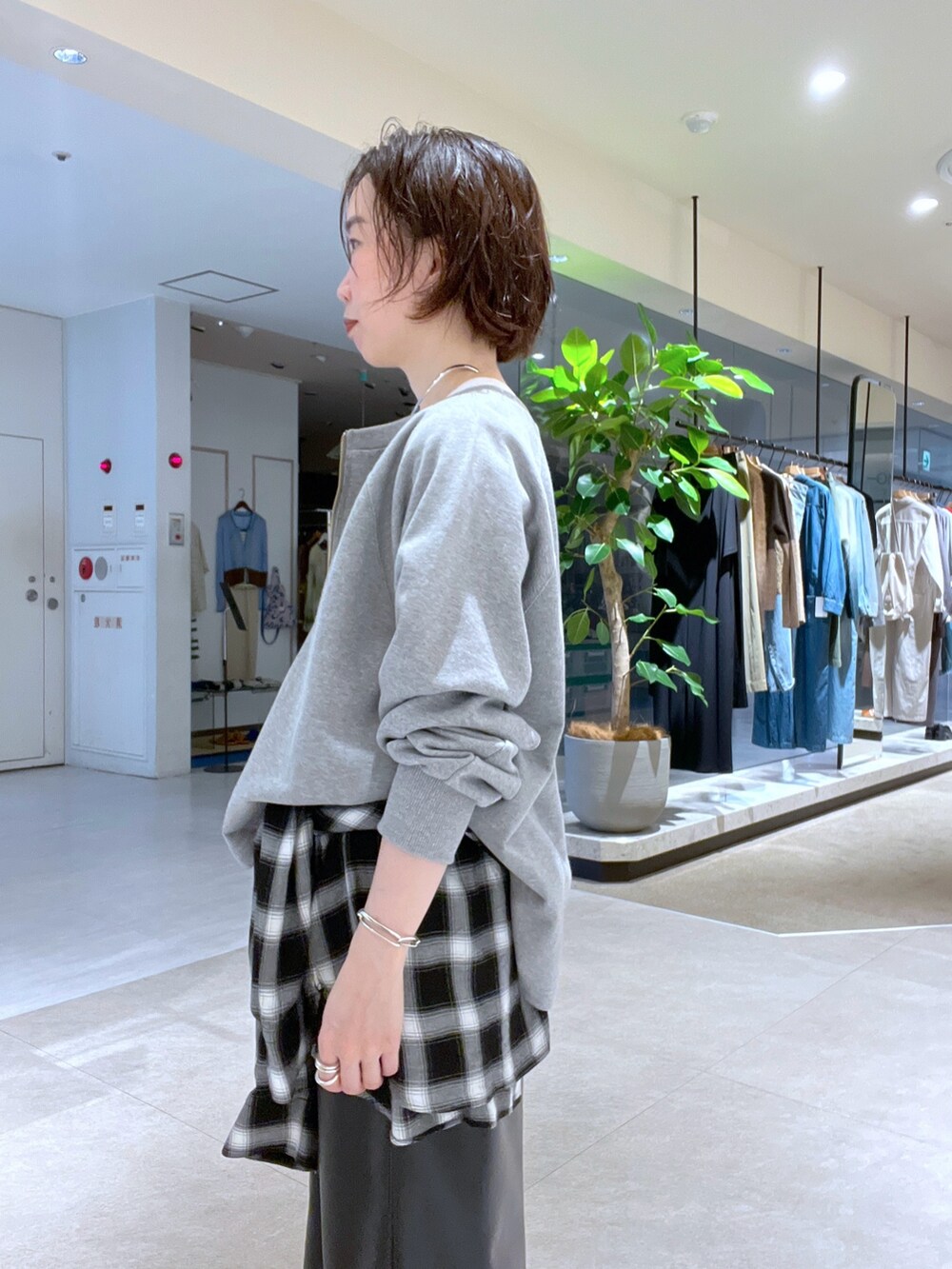 グレー系のスウェット、ブラウン系のハンドバッグ、ブラック系のシャツ/ブラウスを着用したレディースの秋コーディネートの5枚目の写真