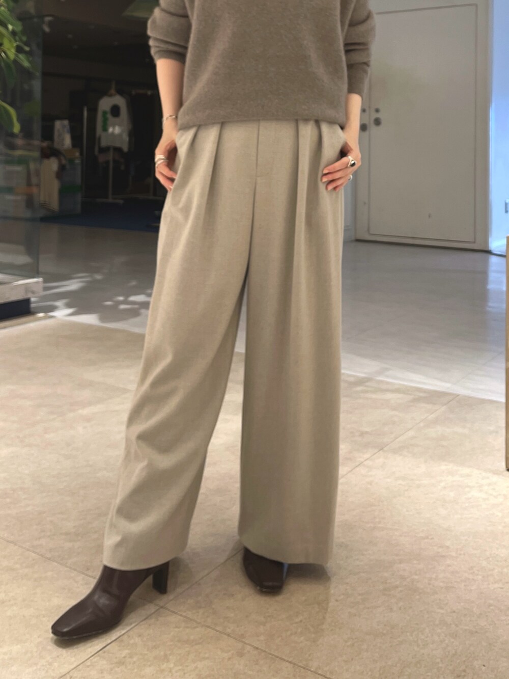 グレー系のニット/セーター、ベージュ系のスラックス、ブラウン系のボストンバッグを着用したレディースの秋コーディネートの8枚目の写真