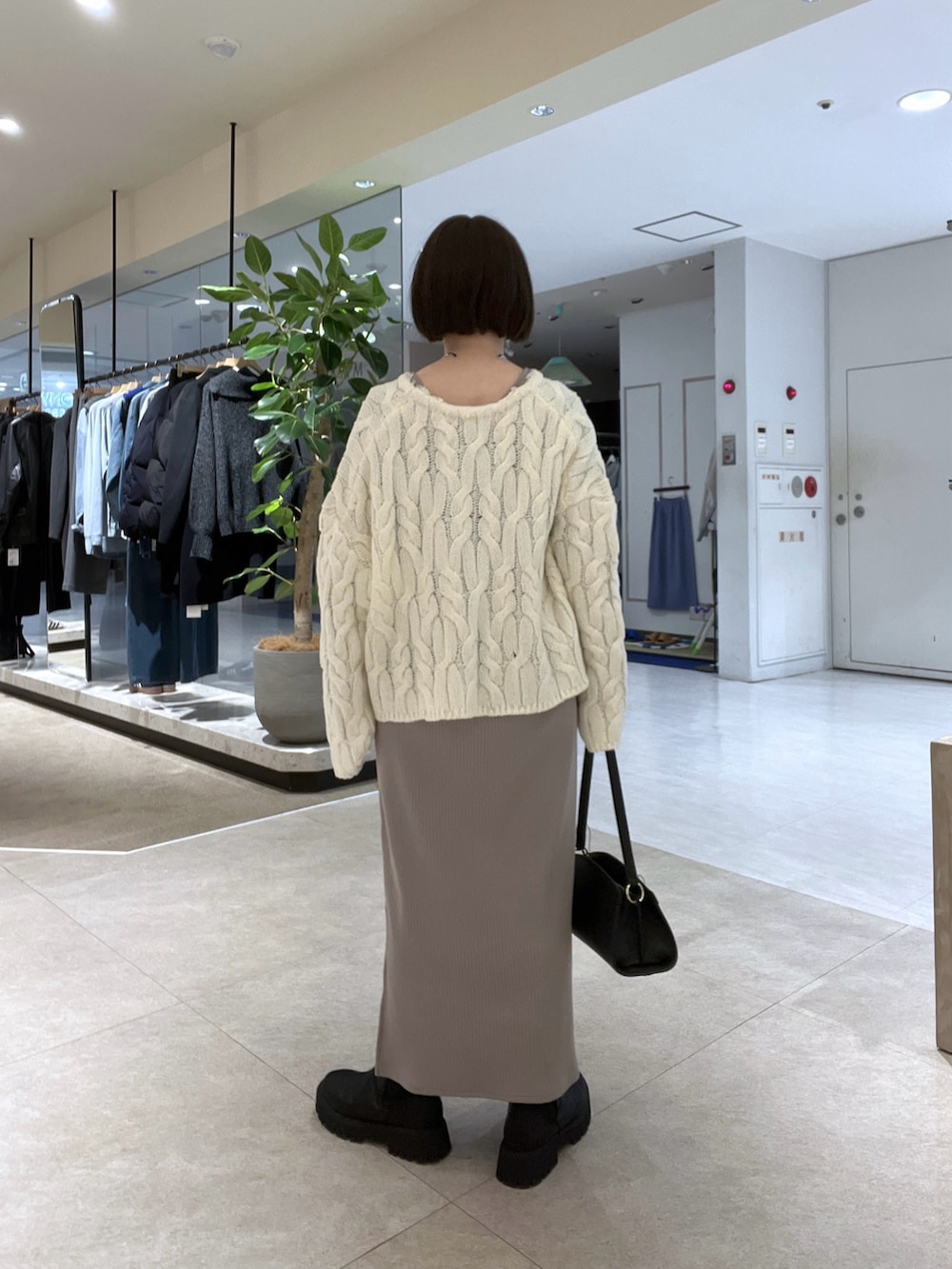 ベージュ系のその他アウター、ホワイト系のニット/セーター、ベージュ系のワンピースを着用したレディースの冬コーディネートの6枚目の写真