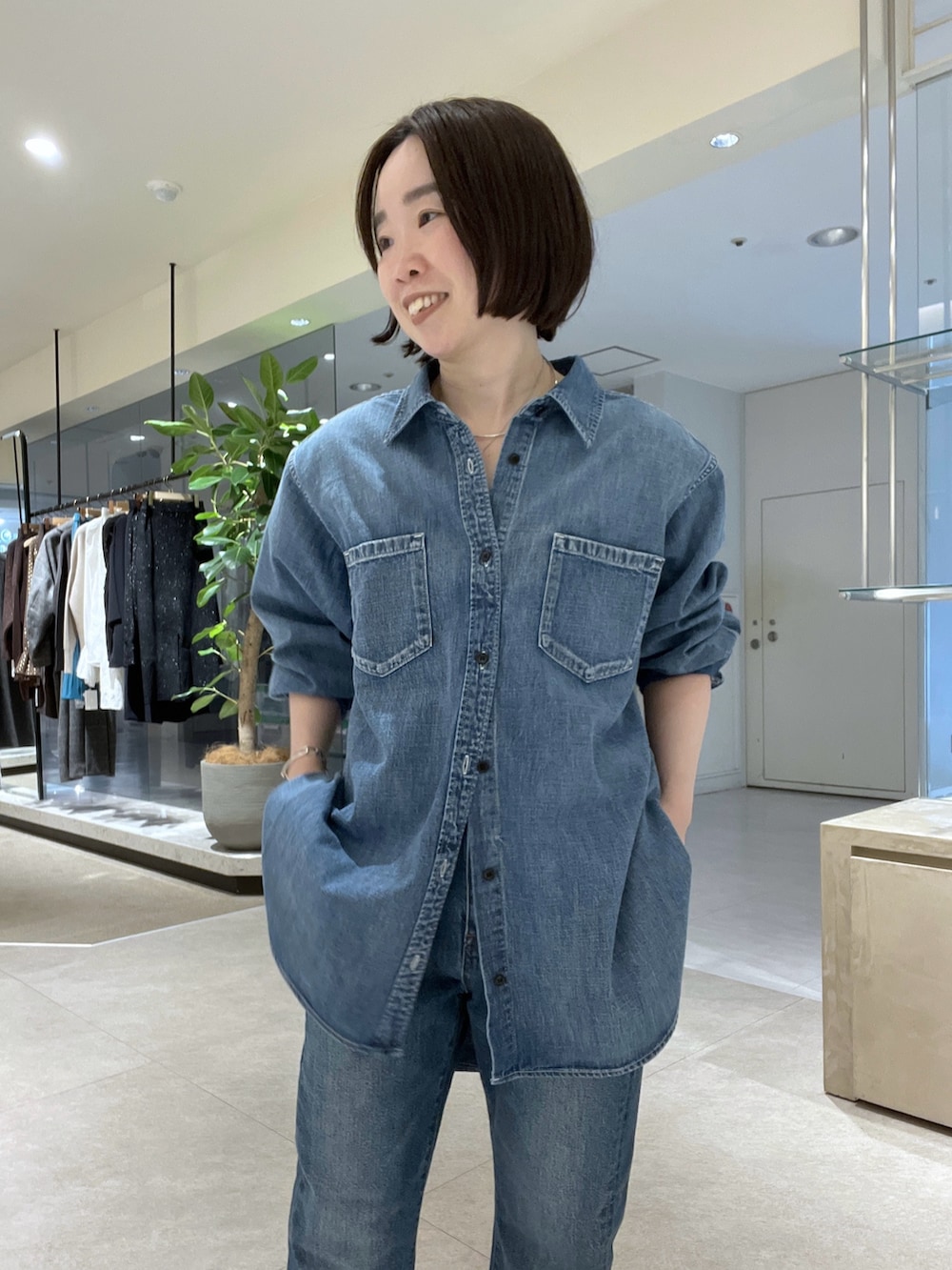 ブルー系のシャツ/ブラウス、ブルー系のデニムパンツ、イエロー系のボストンバッグを着用したレディースの冬コーディネートの4枚目の写真