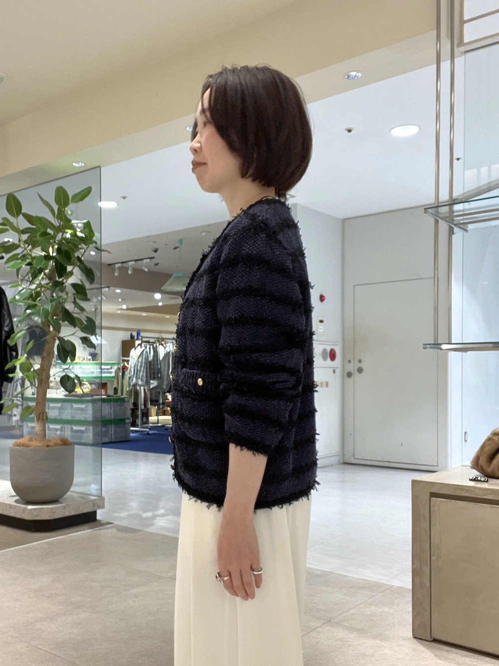 ブルー系のカーディガン/ボレロ、ホワイト系のスラックス、ブルー系のシャツ/ブラウスを着用したレディースの冬コーディネートの5枚目の写真