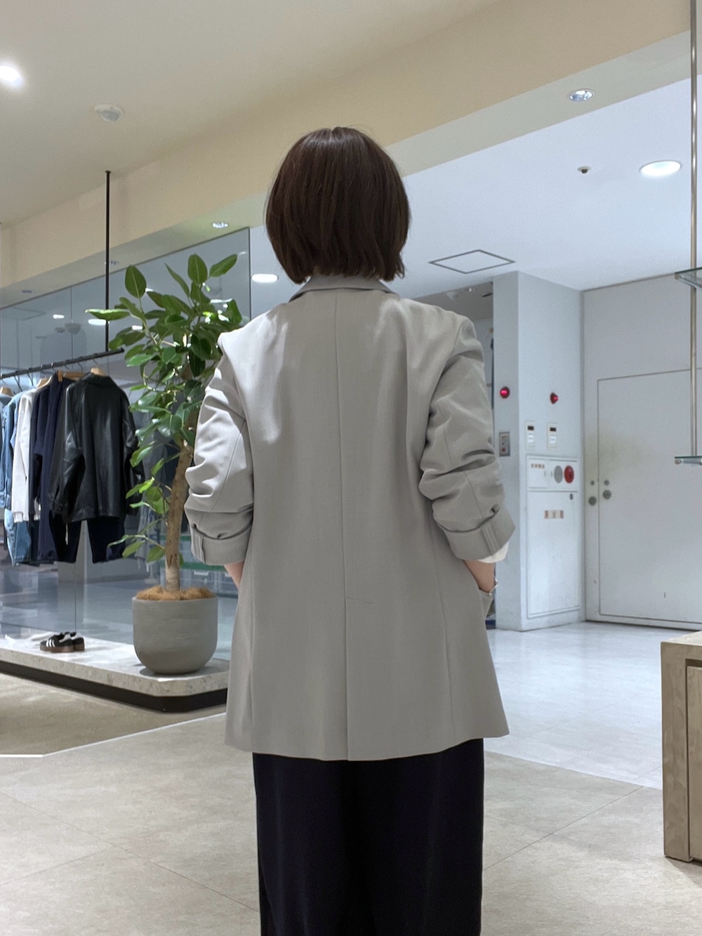 グレー系のテーラードジャケット、ホワイト系のシャツ/ブラウス、ブルー系のスラックスを着用したレディースの冬コーディネートの5枚目の写真