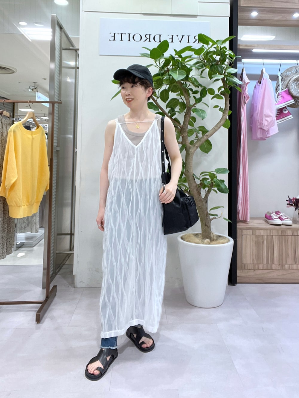 ブルー系のデニムパンツ、ブラウン系のテーラードジャケット、ベージュ系のタンクトップを着用したレディースの春コーディネートの3枚目の写真