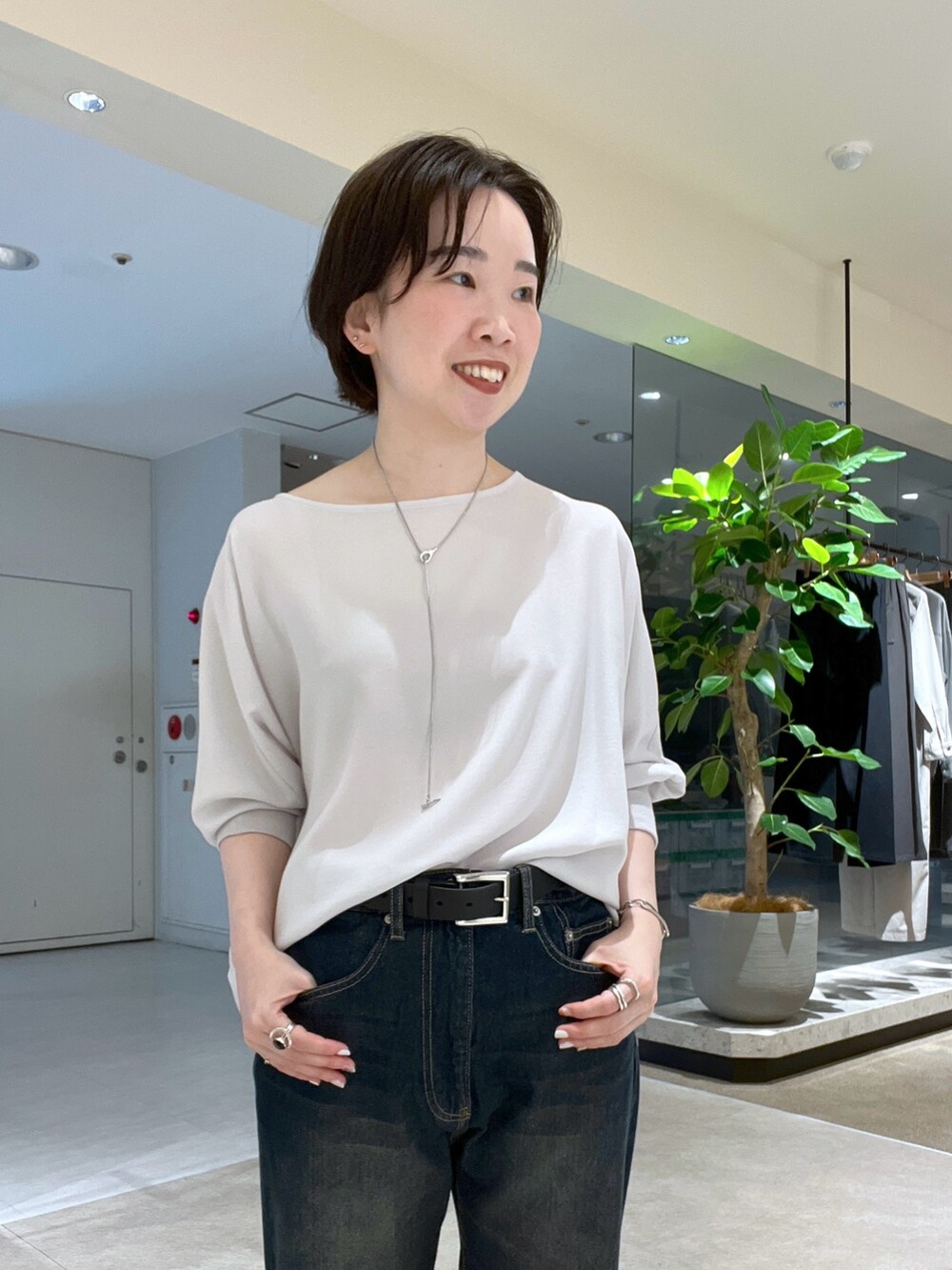 ブルー系のデニムパンツ、ブラック系のハンドバッグ、ブラック系のサンダルを着用したレディースの夏コーディネートの4枚目の写真