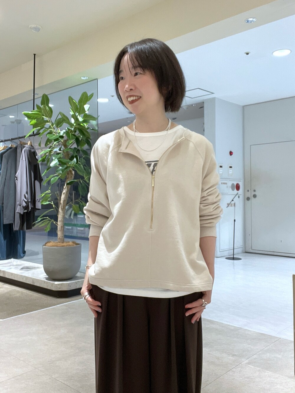 ブラウン系のスラックス、ブラウン系のハンドバッグ、ブラウン系のブーツを着用したレディースの秋コーディネートの4枚目の写真