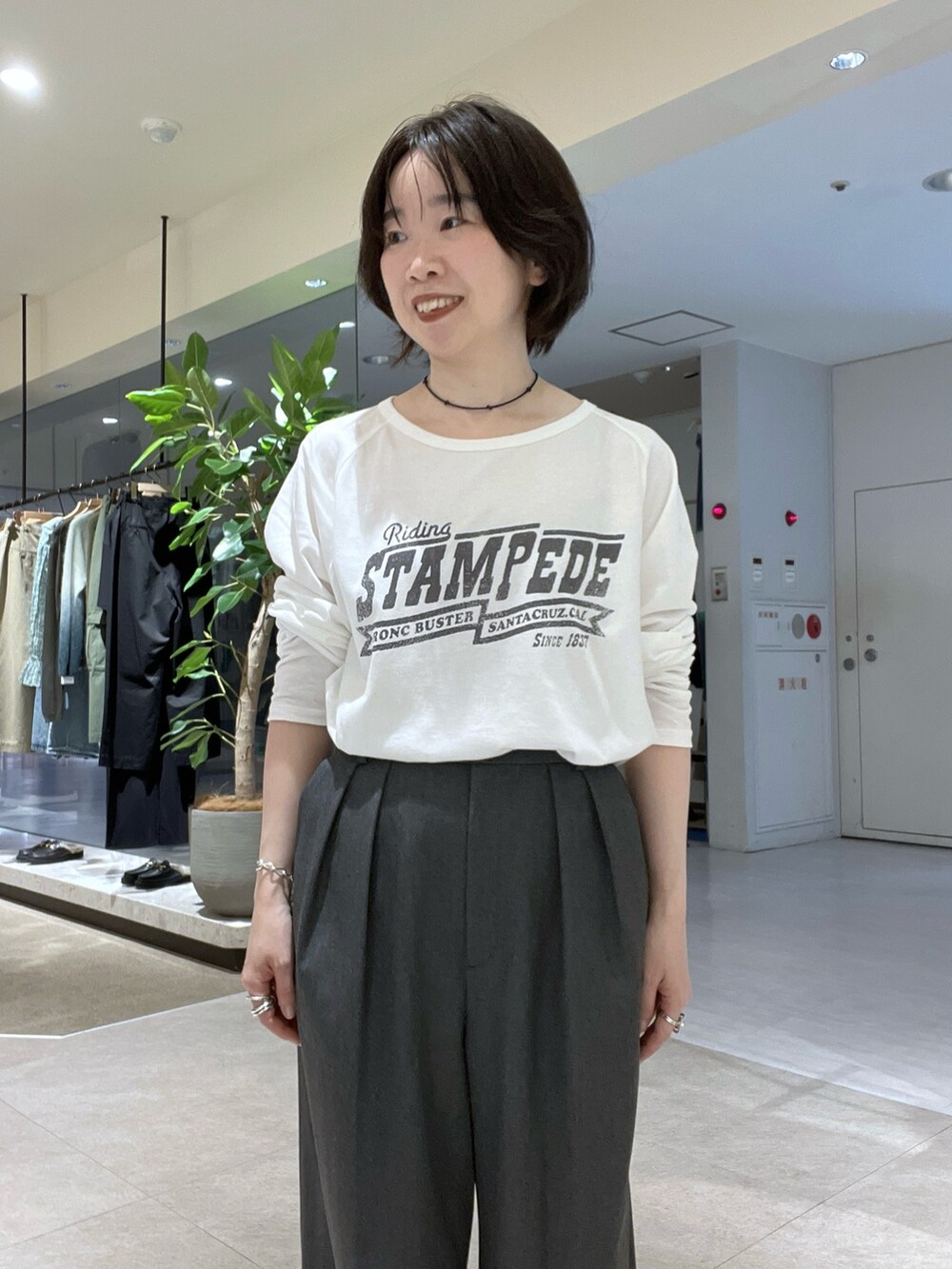 グレー系のスラックス、ホワイト系のTシャツ/カットソー、ベージュ系のその他アウターを着用したレディースの秋コーディネートの6枚目の写真
