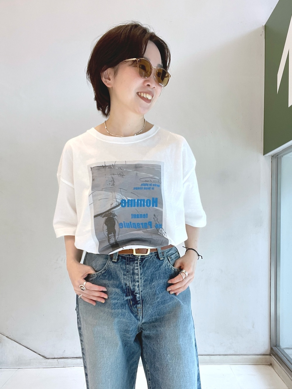 ホワイト系のTシャツ/カットソー、ブルー系のデニムパンツ、ブルー系のハンドバッグを着用したレディースの夏コーディネートの2枚目の写真
