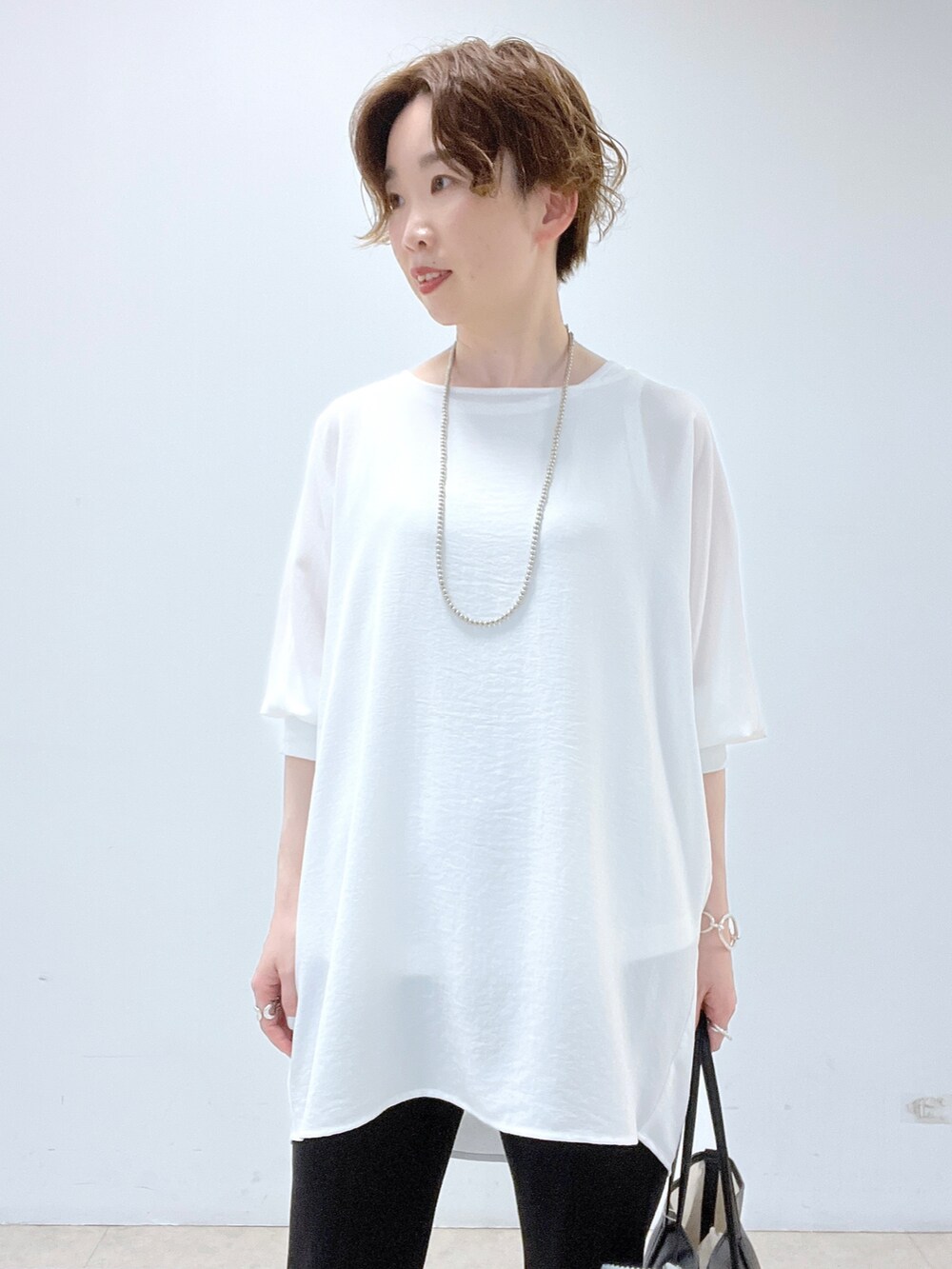 ブラック系のトートバッグ、ホワイト系のシャツ/ブラウス、ホワイト系のタンクトップを着用したレディースの春コーディネートの3枚目の写真