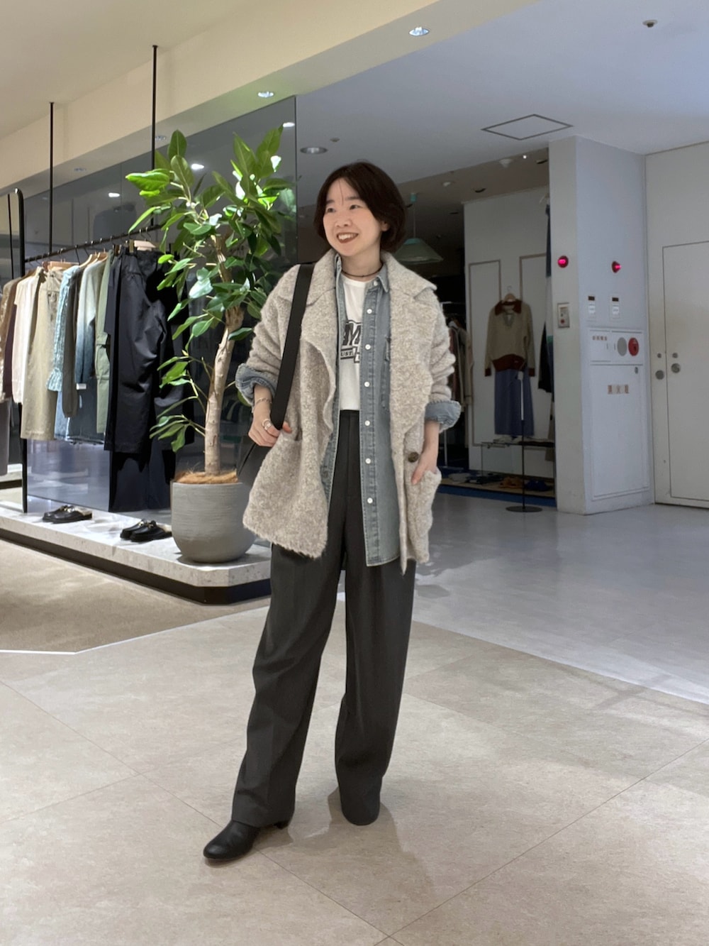 グレー系のスラックス、ホワイト系のTシャツ/カットソー、ベージュ系のその他アウターを着用したレディースの秋コーディネートの2枚目の写真