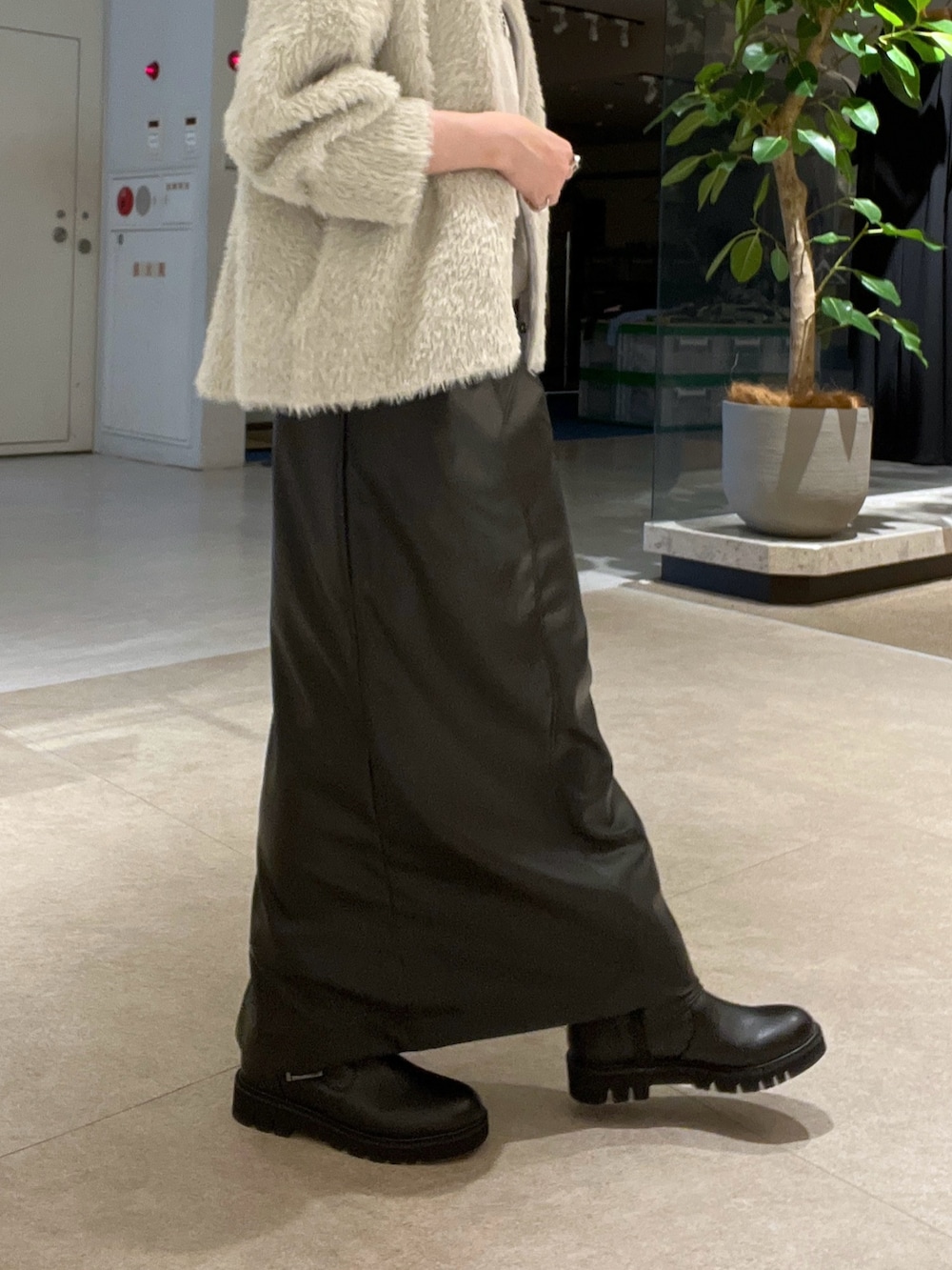 ベージュ系のカーディガン/ボレロ、ブラック系のスカート、ホワイト系のTシャツ/カットソーを着用したレディースの秋コーディネートの9枚目の写真